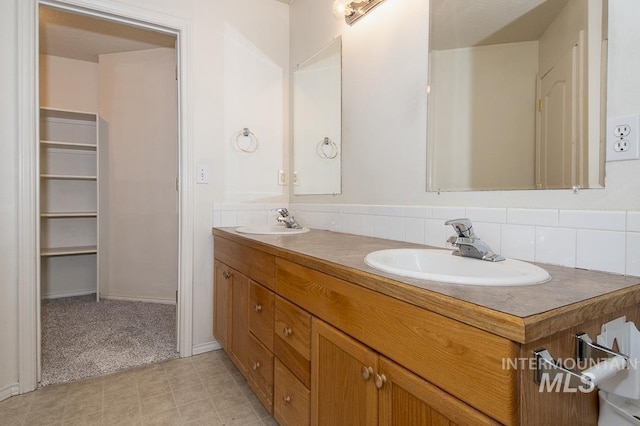 full bath featuring double vanity, tasteful backsplash, and a sink