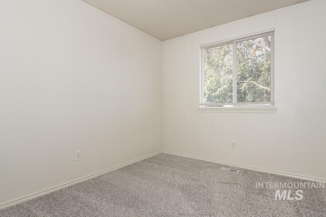 carpeted empty room with visible vents and baseboards