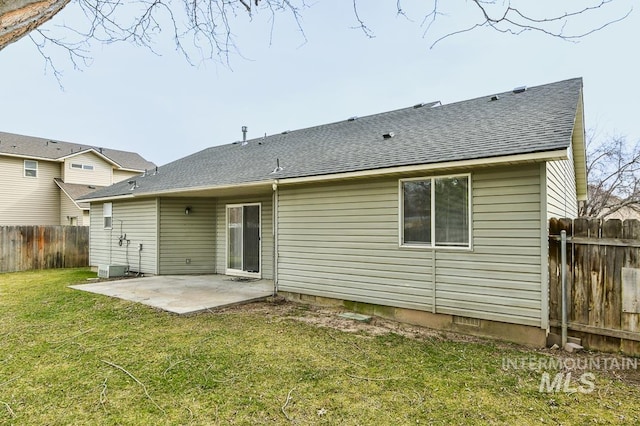 back of house with a shingled roof, fence, crawl space, a lawn, and a patio area