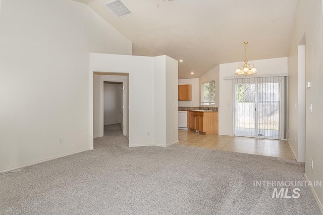 unfurnished living room featuring visible vents, a chandelier, light colored carpet, recessed lighting, and high vaulted ceiling