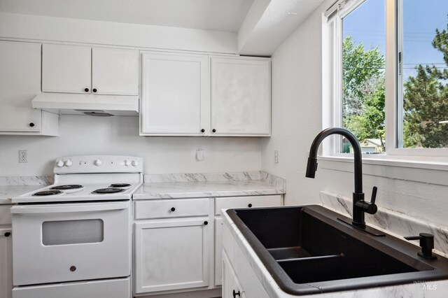 228 N Latah St, Boise, ID 83706 - kitchen featuring white range with electric stovetop, under cabinet range hood, plenty of natural light, and white cabinetry