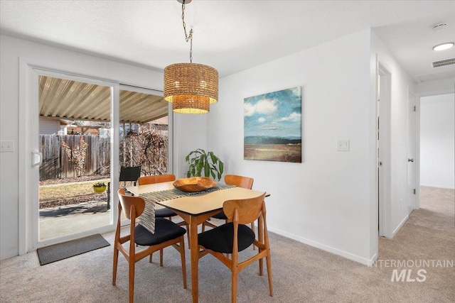 dining room with light carpet, baseboards, and visible vents