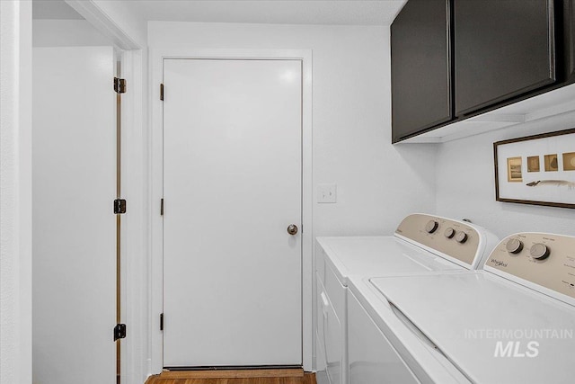 clothes washing area with washing machine and dryer and cabinet space