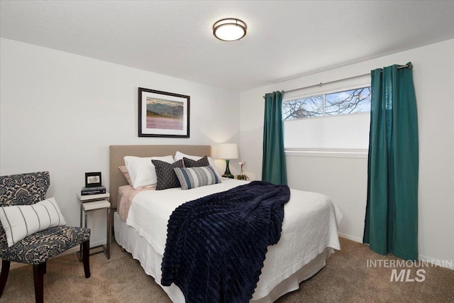 bedroom featuring a textured ceiling, carpet, and baseboards