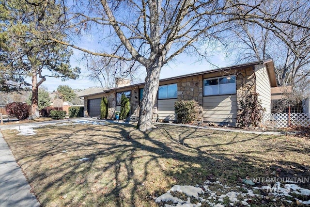 view of front of house featuring a garage, stone siding, a chimney, and concrete driveway