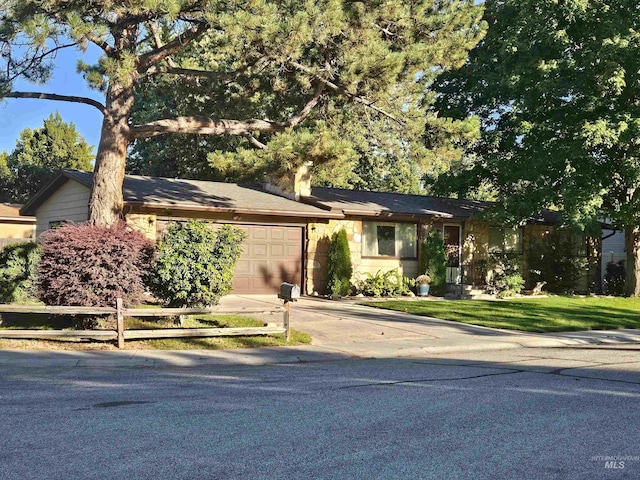 view of front of property with a garage, concrete driveway, and fence