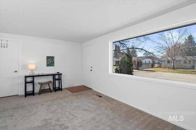 interior space with visible vents, baseboards, and a textured ceiling