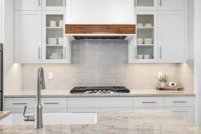 kitchen with glass insert cabinets, white cabinetry, and stainless steel gas cooktop
