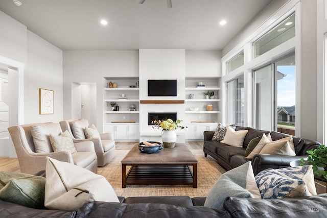 living room with a fireplace, light wood-style flooring, and recessed lighting