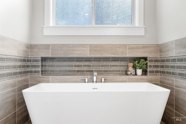 full bath featuring a soaking tub and tile walls