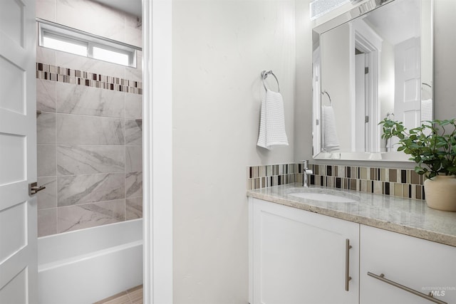 bathroom with shower / bath combination, backsplash, and vanity