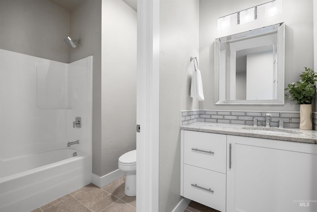 full bath featuring tile patterned flooring, vanity, toilet, baseboards, and shower / washtub combination