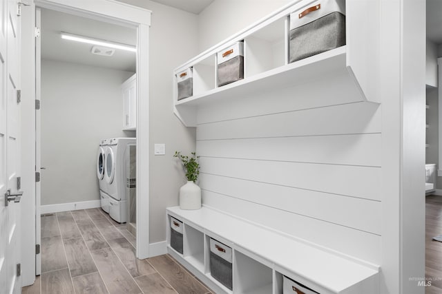 mudroom featuring light wood finished floors, baseboards, washing machine and dryer, and visible vents