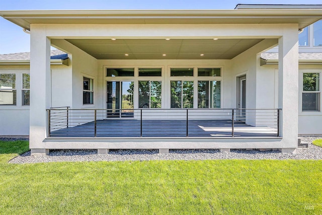 entrance to property featuring stucco siding, a porch, and a yard