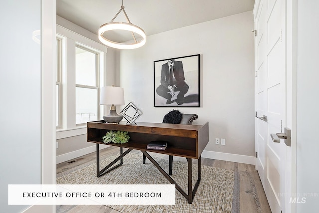 office with baseboards, visible vents, and wood finished floors