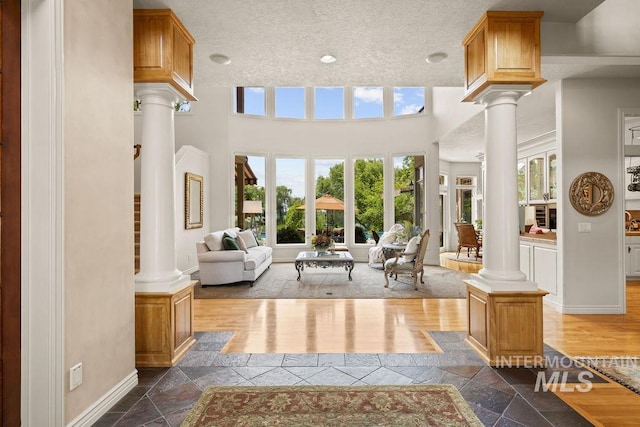 4119 N Park Ln, Eagle, ID 83616 - living room featuring decorative columns, stone tile floors, and a textured ceiling