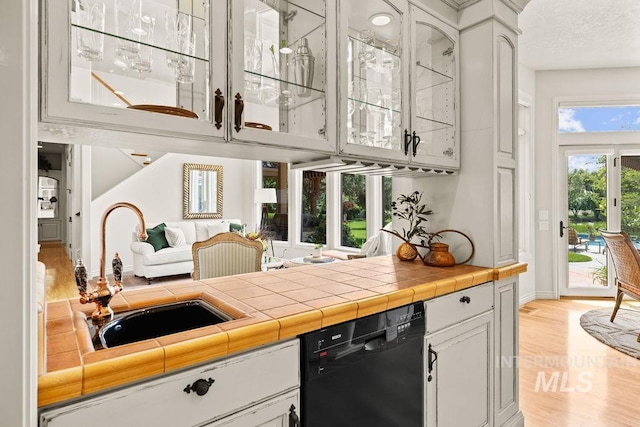 4119 N Park Ln, Eagle, ID 83616 - kitchen with dishwasher, glass insert cabinets, light wood-type flooring, white cabinets, and light countertops