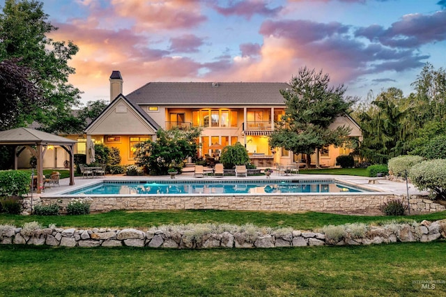 4119 N Park Ln, Eagle, ID 83616 - back of house at dusk featuring a gazebo, a balcony, a yard, and a chimney