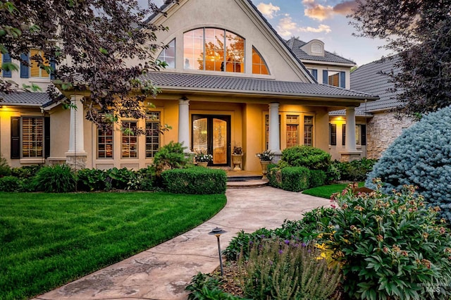 4119 N Park Ln, Eagle, ID 83616 - exterior entry at dusk with stucco siding, a lawn, and a porch