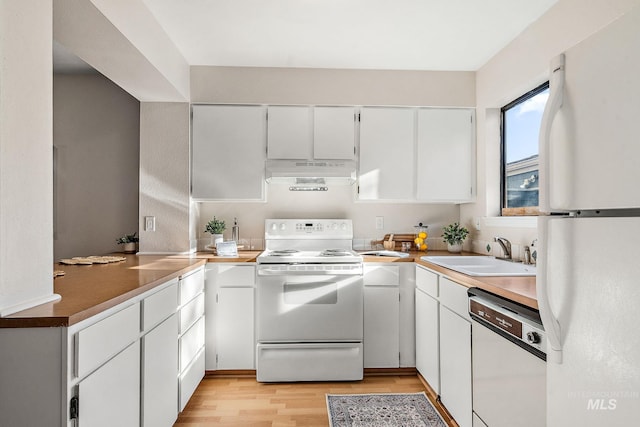 kitchen featuring sink, white cabinets, light hardwood / wood-style floors, and white appliances