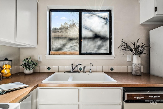 kitchen with white cabinetry, sink, and dishwasher