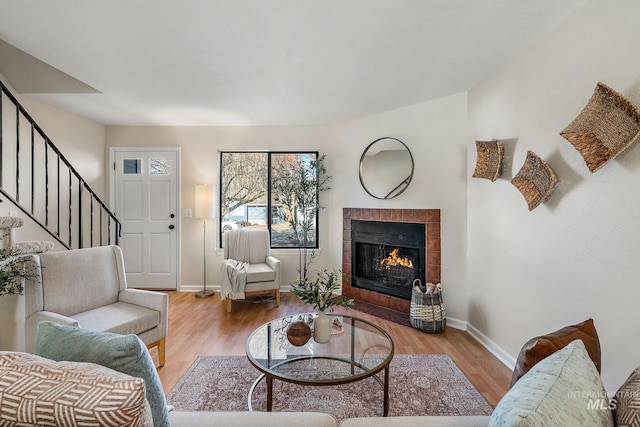 living room with light wood-type flooring and a tile fireplace