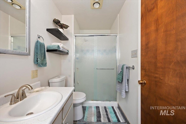 full bath with vanity, toilet, a stall shower, and tile patterned flooring