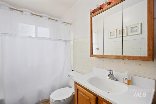 full bathroom with vanity, tile walls, and toilet