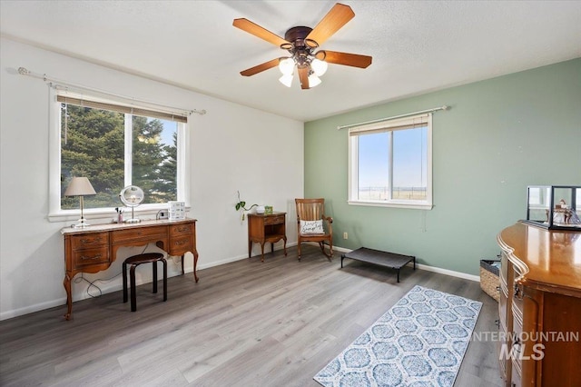 sitting room featuring baseboards, plenty of natural light, wood finished floors, and a ceiling fan