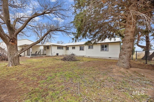 view of front of home featuring crawl space and fence