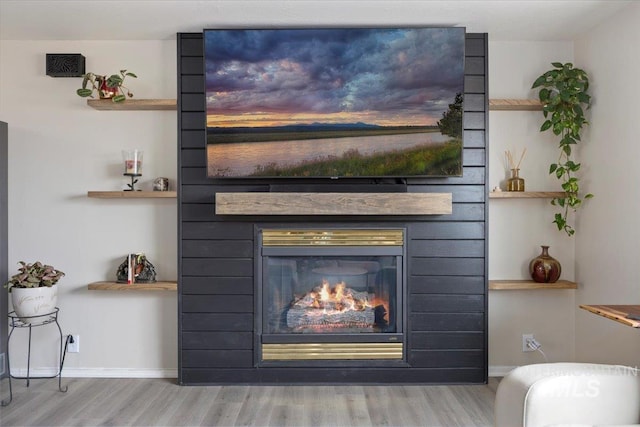 interior details featuring baseboards, wood finished floors, and a fireplace