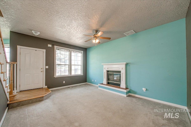 1239 Willow Creek Dr, Nampa, ID 83686 - unfurnished living room with ceiling fan, stairway, carpet flooring, baseboards, and a textured ceiling