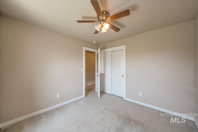 1239 Willow Creek Dr, Nampa, ID 83686 - unfurnished bedroom featuring baseboards, light carpet, a closet, a textured ceiling, and a ceiling fan