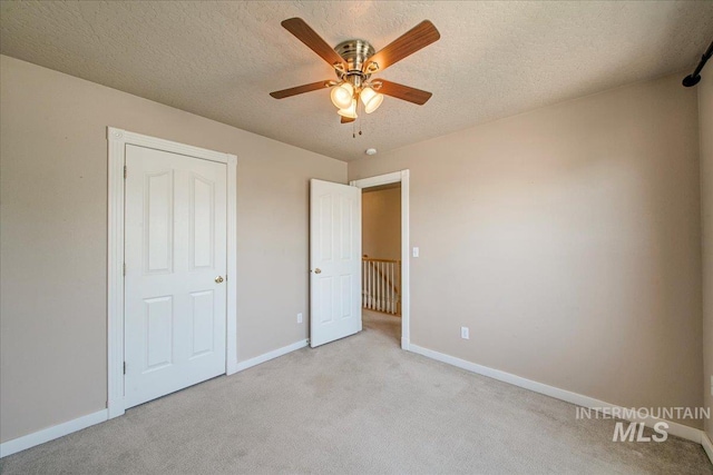 1239 Willow Creek Dr, Nampa, ID 83686 - unfurnished bedroom with light carpet, baseboards, a textured ceiling, and a ceiling fan