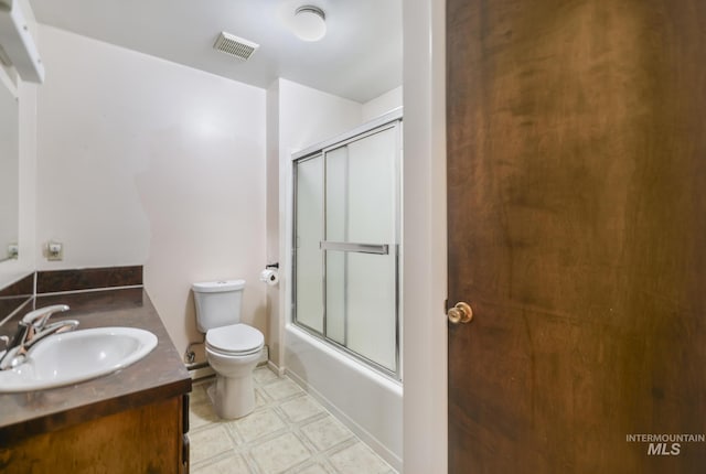 full bathroom featuring vanity, combined bath / shower with glass door, and toilet