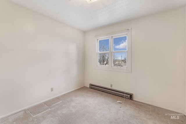 spare room with baseboard heating, light carpet, and a textured ceiling