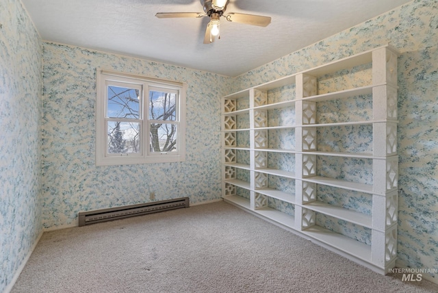 carpeted empty room with a baseboard heating unit, a textured ceiling, and ceiling fan