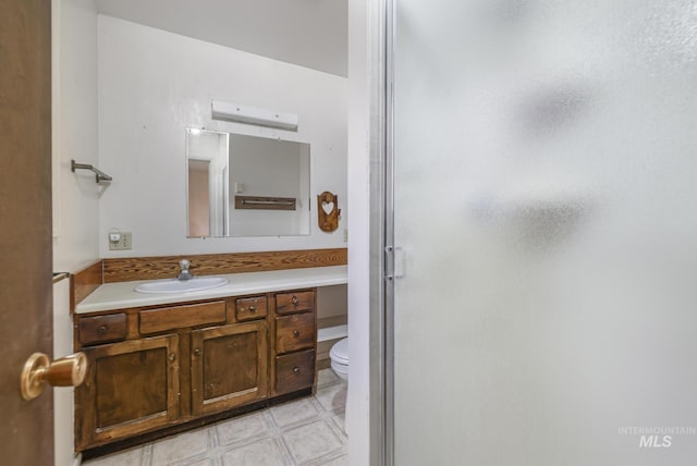 bathroom with vanity, toilet, and walk in shower