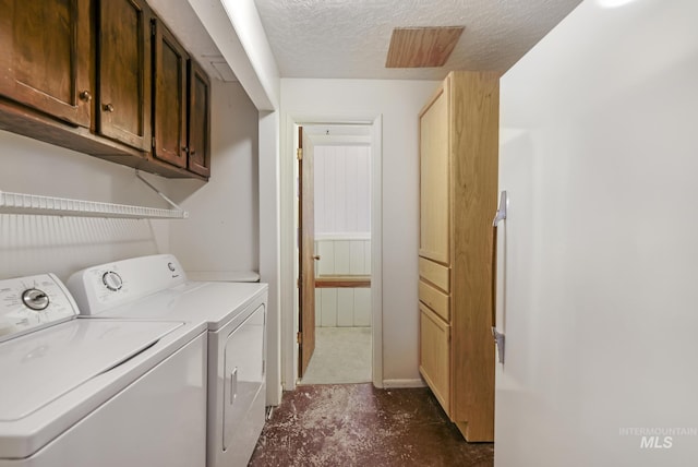 washroom with separate washer and dryer and a textured ceiling