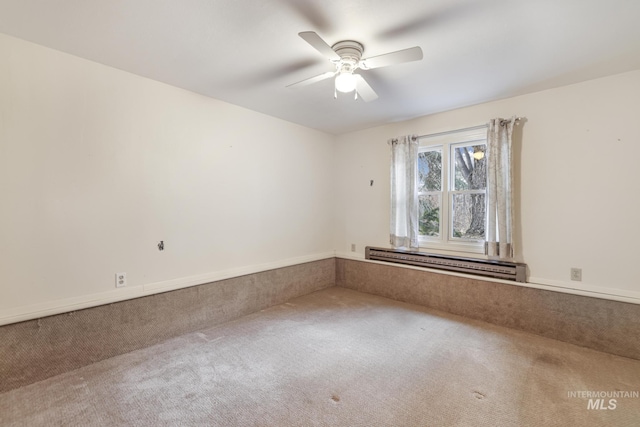 carpeted spare room featuring ceiling fan and baseboard heating