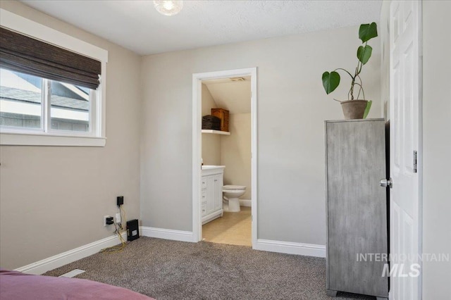 unfurnished bedroom with baseboards, carpet, and ensuite bathroom