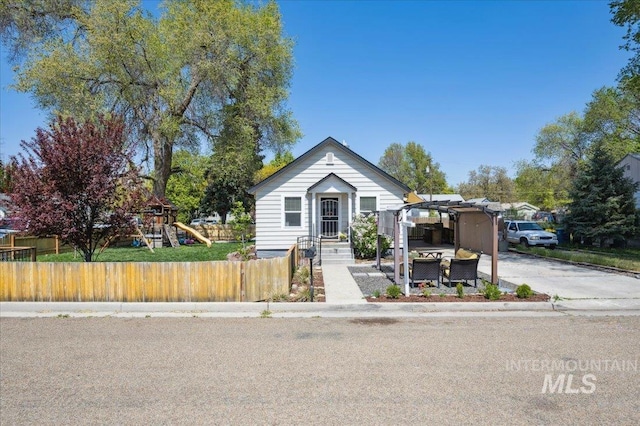 bungalow-style house featuring fence, a pergola, and a playground