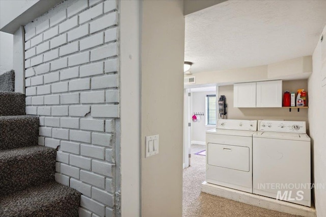 laundry area featuring laundry area, washing machine and dryer, visible vents, and light carpet
