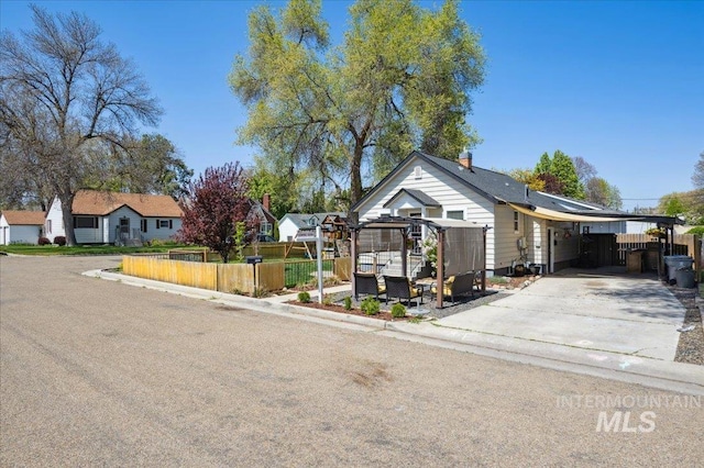 view of front facade featuring fence, a carport, and concrete driveway