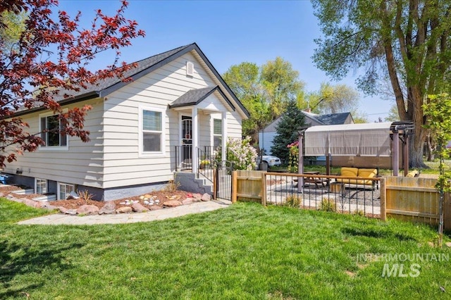 back of property featuring fence and a yard