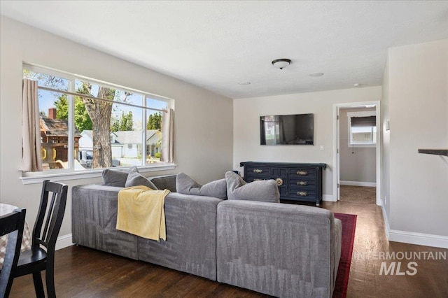 living area with baseboards and wood finished floors