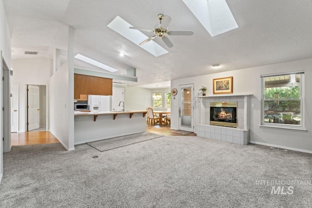 1548 N Vineyards Ave, Meridian, ID 83642 - living area featuring a skylight, carpet flooring, a fireplace, baseboards, and a textured ceiling