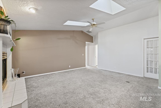 1548 N Vineyards Ave, Meridian, ID 83642 - unfurnished living room with a skylight, vaulted ceiling, carpet, a fireplace with raised hearth, and baseboards