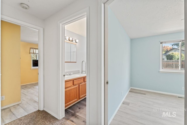 1548 N Vineyards Ave, Meridian, ID 83642 - hall featuring plenty of natural light, a sink, light wood-style floors, and a textured ceiling