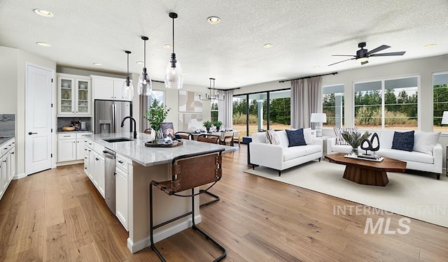 kitchen featuring a kitchen bar, stainless steel appliances, wood finished floors, and open floor plan